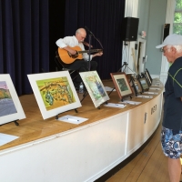 Tom Pirozzoli entertains while guests view the art.  Tom was also a contributing artist.
